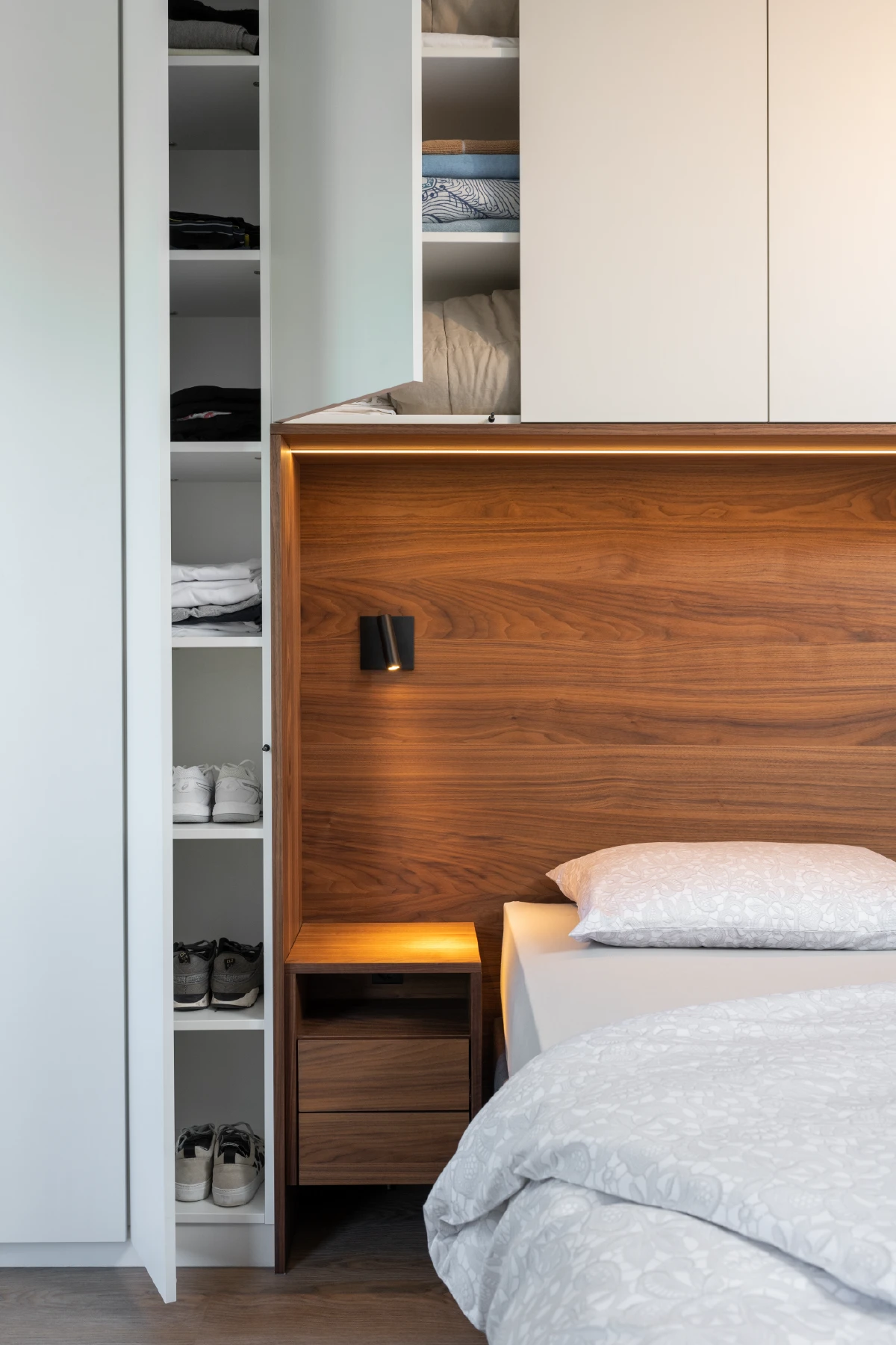 Detail van het bed met kastombouw en zwevend nachtkastje