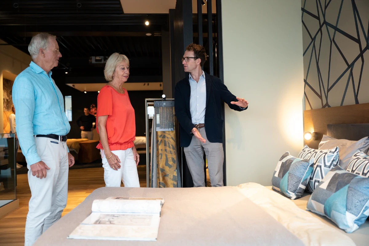 advsieur demonstreert in showroom makkelijk op te maken bed