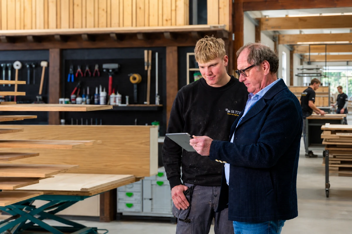 Wim legt een van de jongens uit hoe het moet, in onze eigen werkplaats in Moordrecht