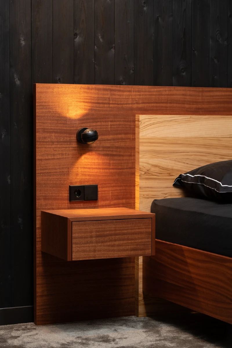 Mahonie nachtkastje naast het bed