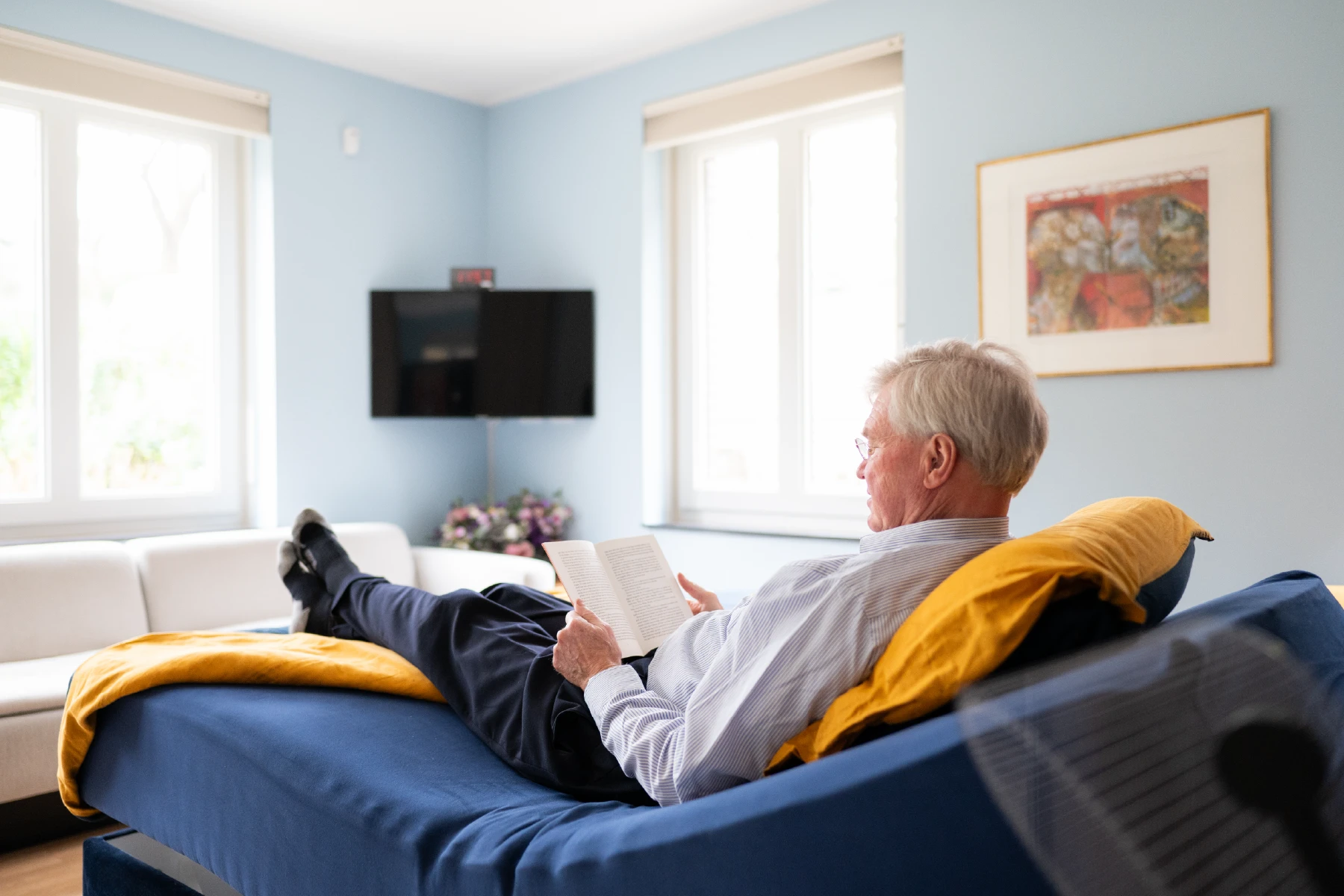 Luc leest ontspannen een boek op bed, terwijl er een FPS-programma draait