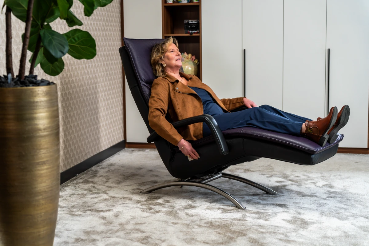 Vrouw ligt ontspannen in de VITA Sentation powernapstoel