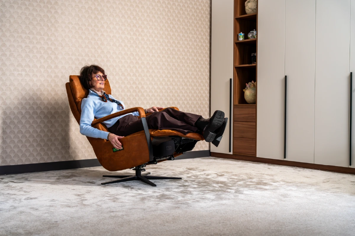 Dame ligt ontspannen in een elektrische relaxfauteuil