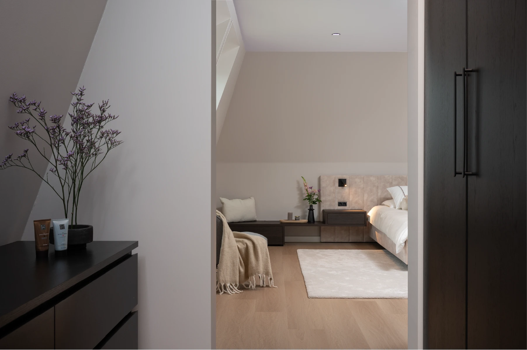 Zolderkamer met bed onder schuin dak