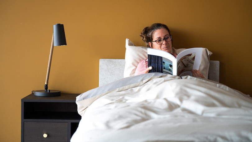 vrouw-leest-in-1-persoons-hoog-laag-boxspring-test vrouw leest in 1 persoons hoog laag bed