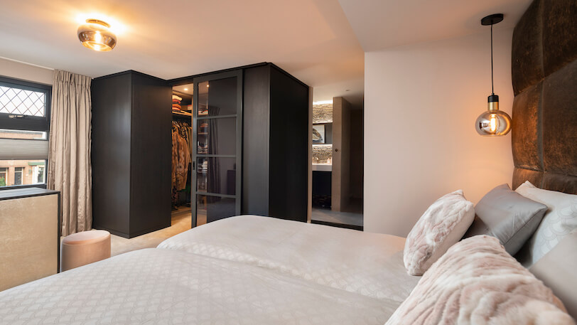 hotel chique slaapkamer met hoog bed en inloopkast