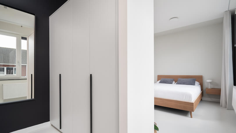 moderne rustgevende slaapkamer met houten bed en inloopkast