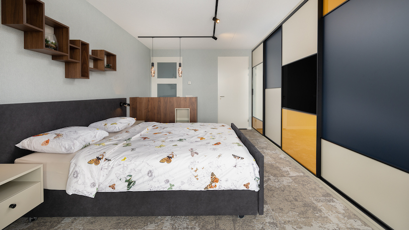 luxe slaapkamer met hoog laag bed en schuifwandkast