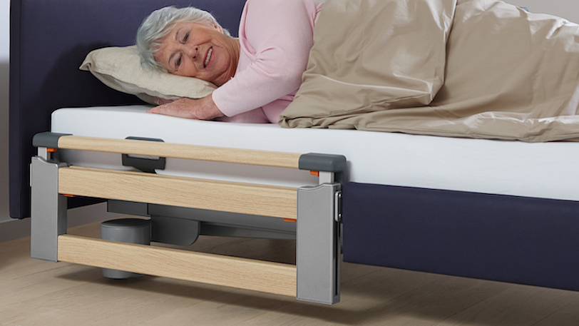 oudere dame ligt in bed met inklapbaar bedhek