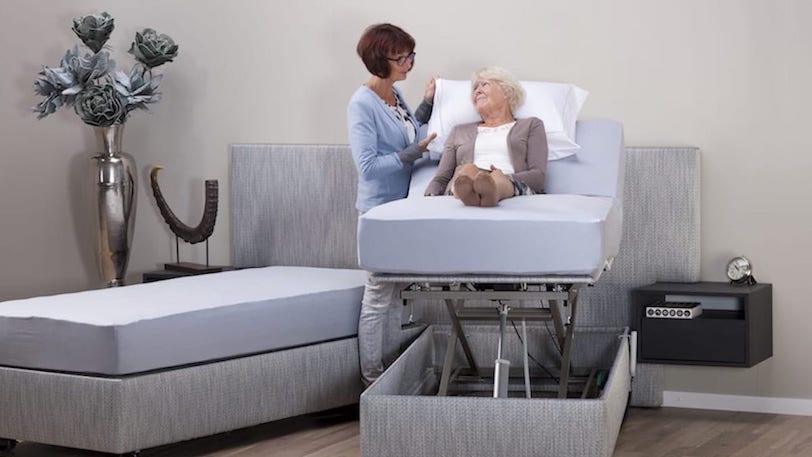 thuiszorg helpt oudere vrouw op bed