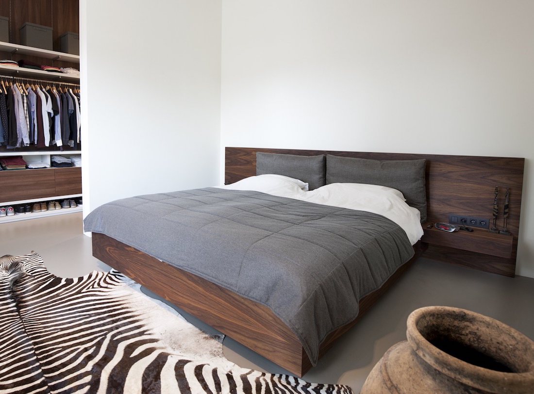 moderne slaapkamer met houten bed en inloopkast
