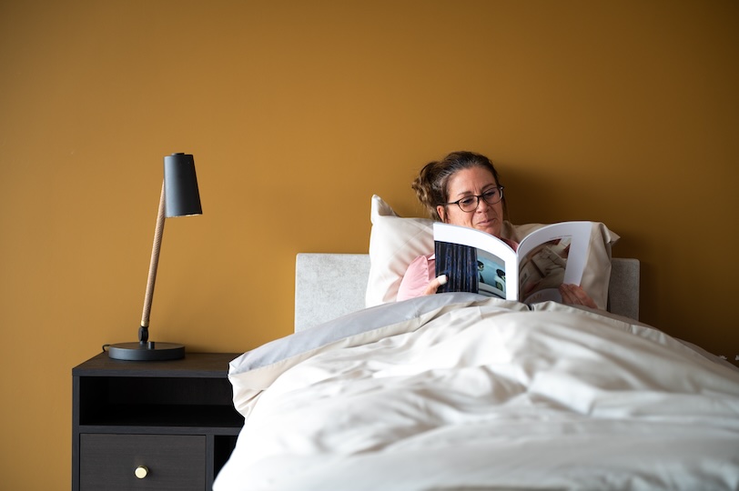 vrouw leest in 1-persoons seniorenbed