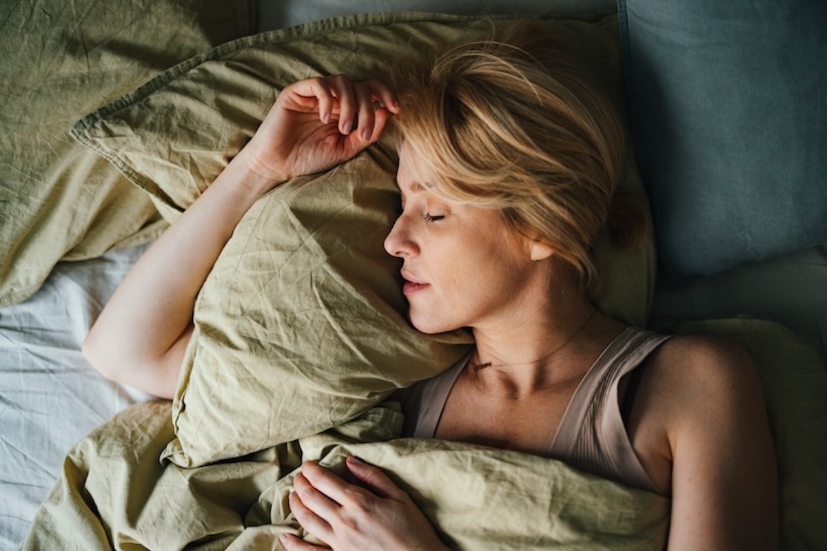 Vrouw slaapt ontspannen met hoofdkussen in De Suite bed