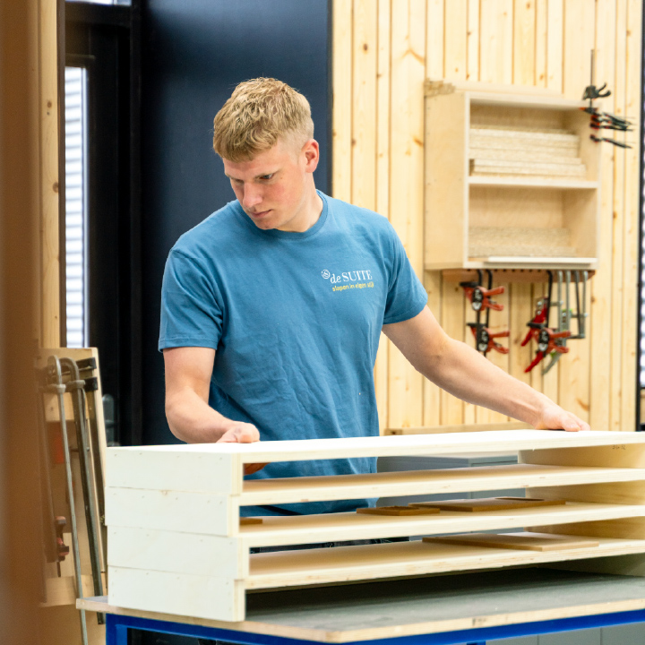 meubelmamer bezig met houten bed