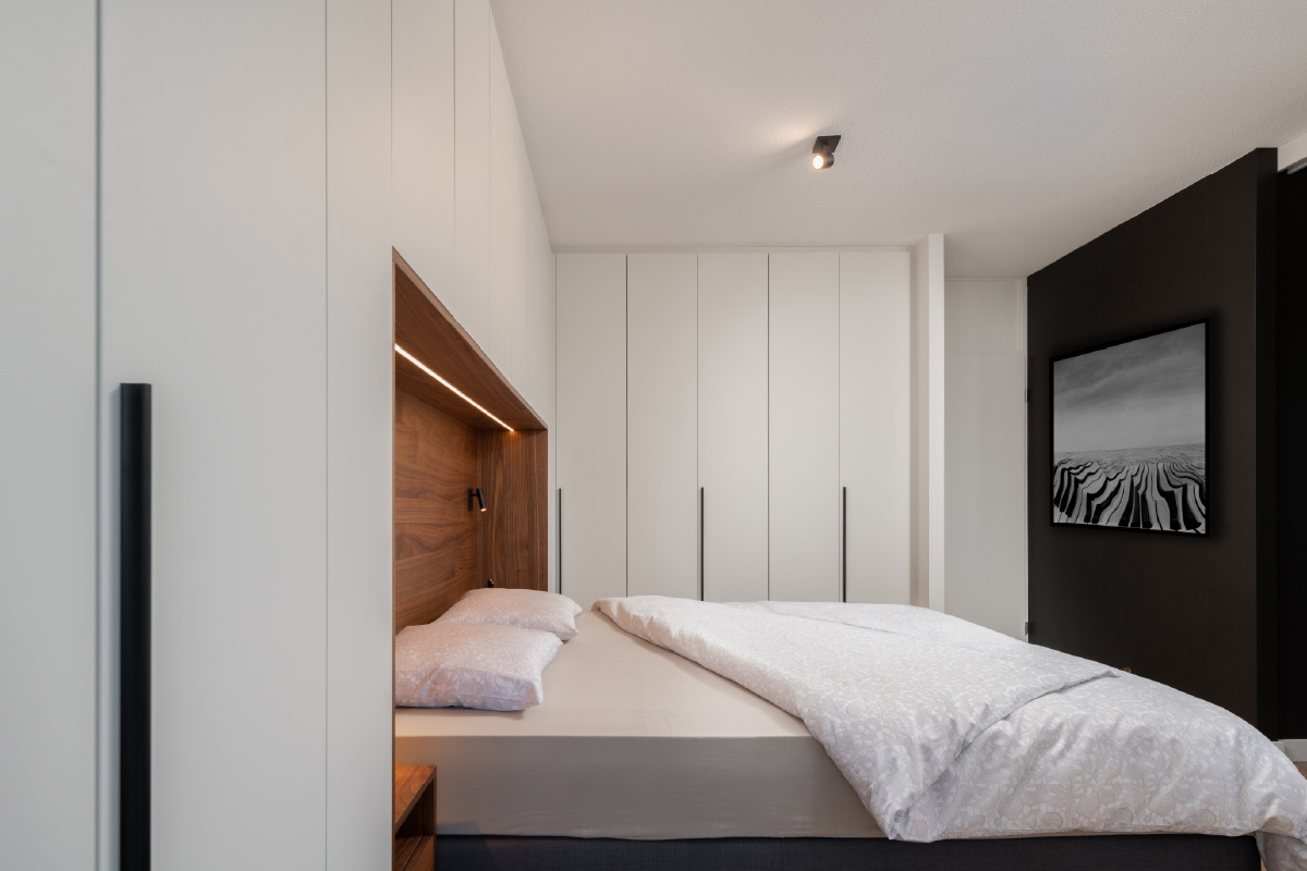 Compacte slaapkamer met stijlvolle bed met kastombouw in lichte tinten