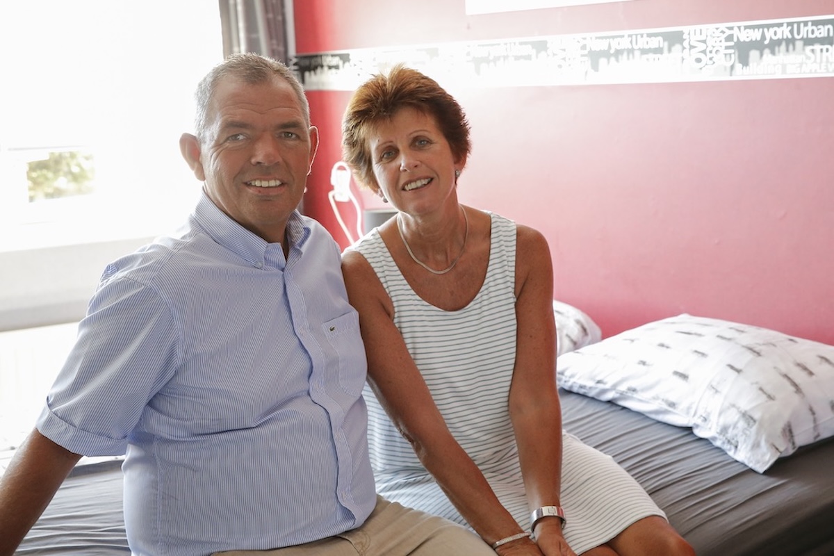 klant met Parkinson ziten op bed samen met partner