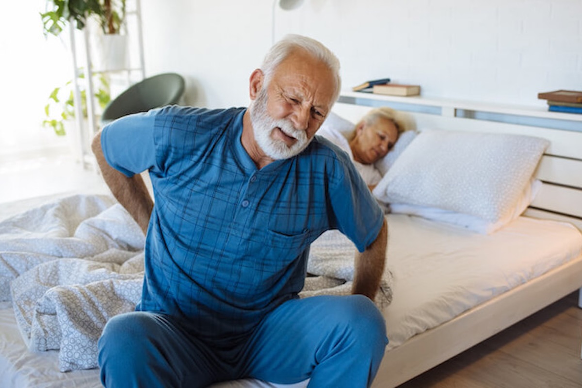 man op bed met heuppijn