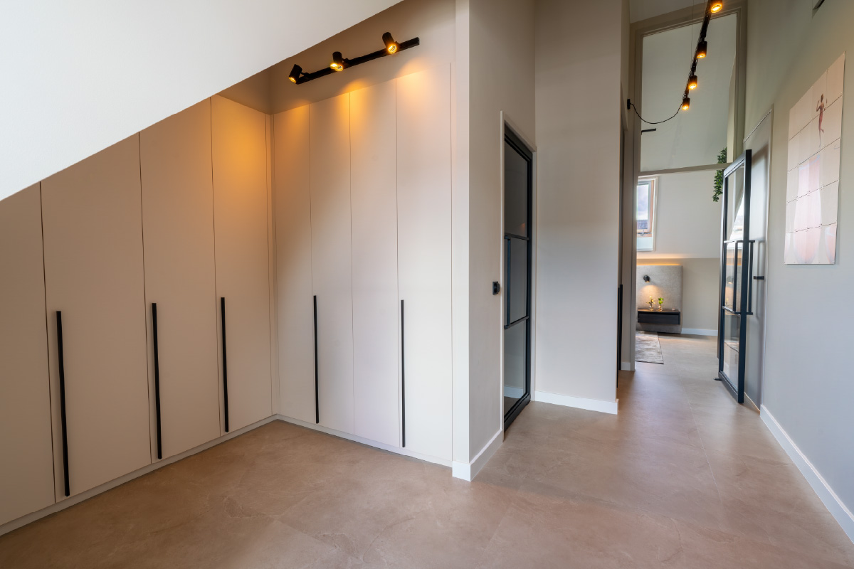 Doorkijk naar werkhoek met bureau naast het design bed