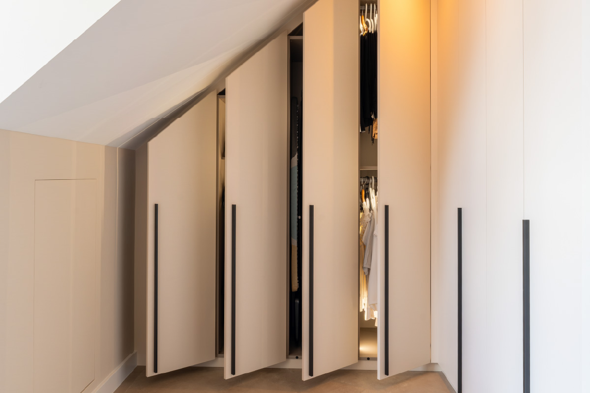 Detail van bedombouw met geïntegreerde bedlampen en paneelwand