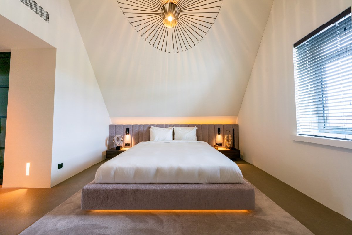 Design bed Formosa onder het schuine dak met brede ombouw en zwevende plint