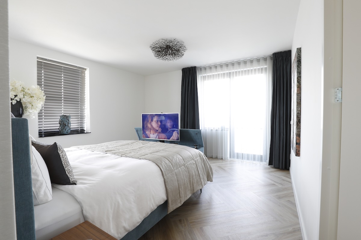 Moderne slaapkamer met inloopkast achter het bed