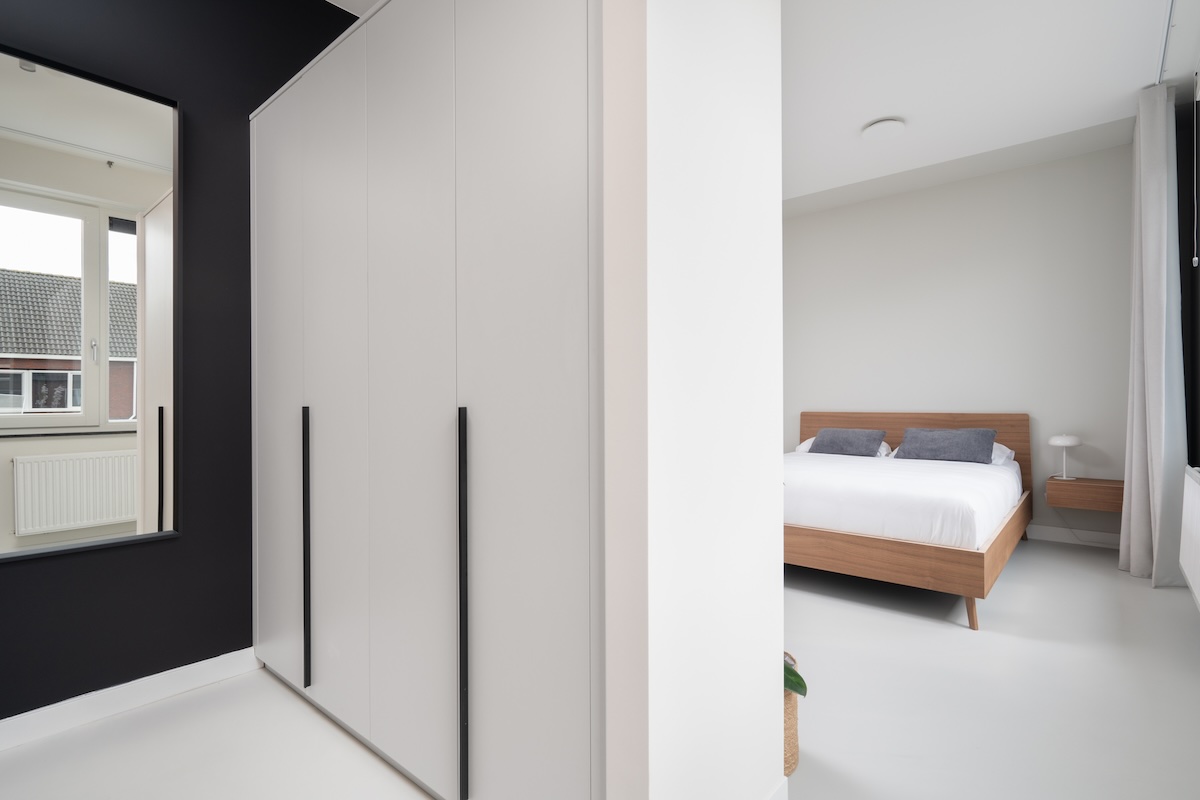 Rustgevende moderne slaapkamer met houten bed en inloopkast