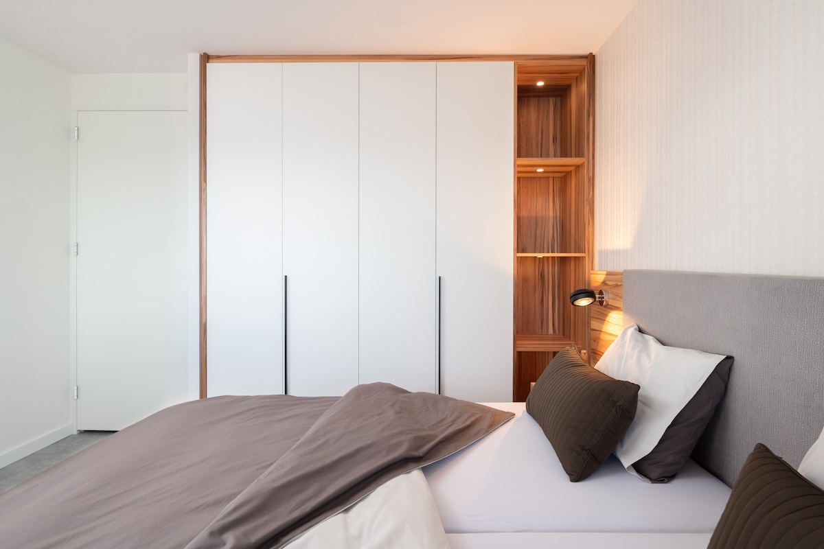 Roomdivider met laden en geïntegreerde tv-lift in slaapkamer