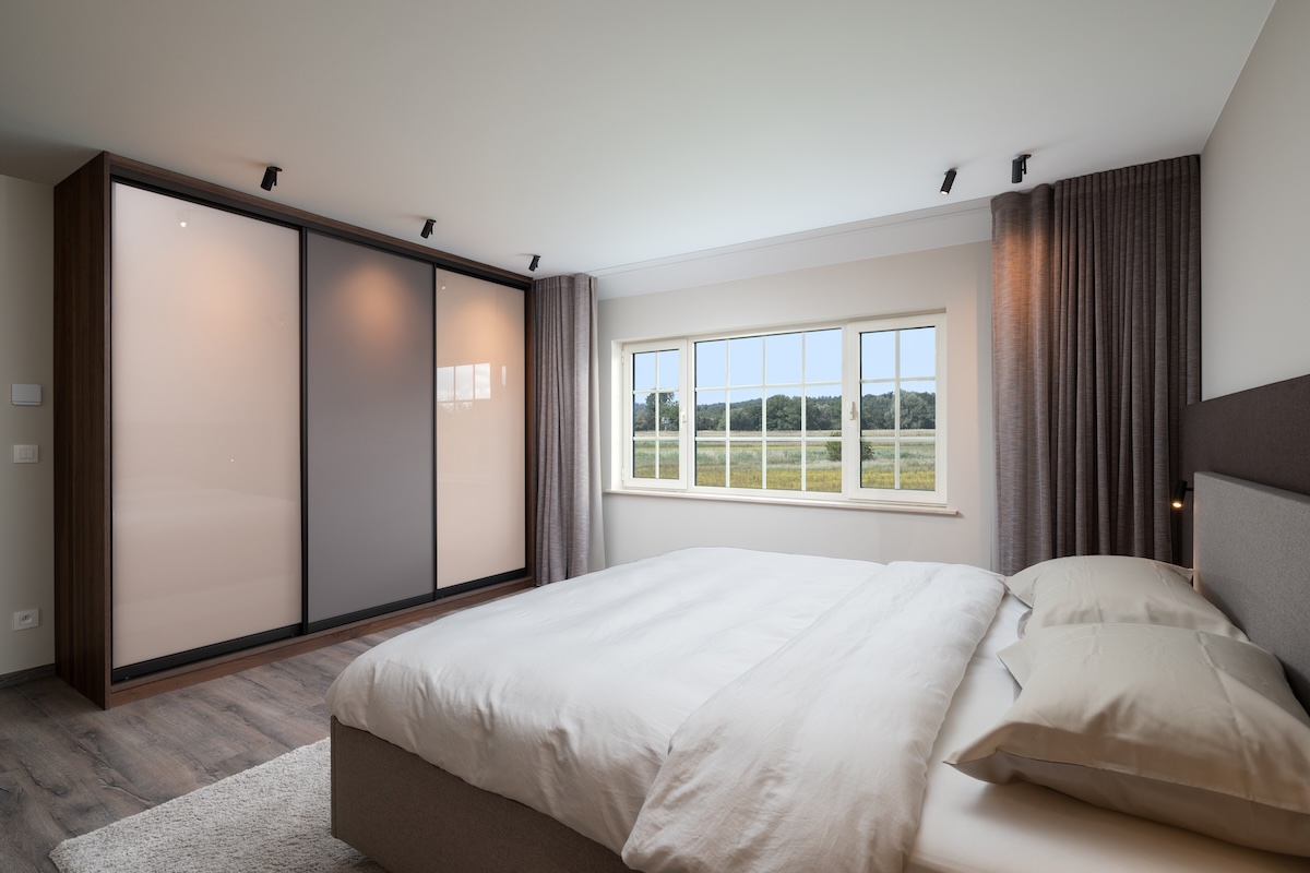 Moderne slaapkamer met houten bed en kastenwand